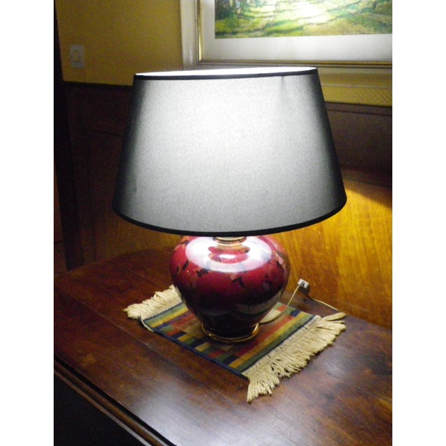 Dolphin-style lamp with a speckled, cloud-like glazed ceramic base reminiscent of flamed enamels, in ruby, black, red, and...