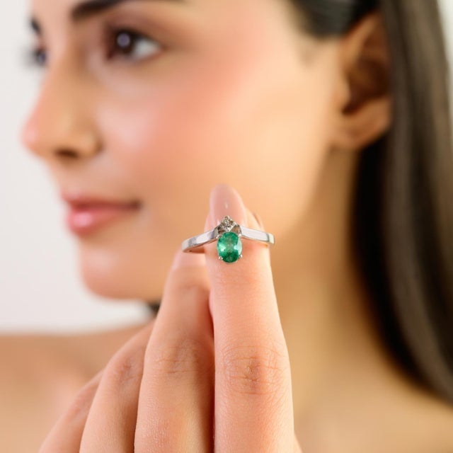 This elegant Carat&her solitaire ring is crafted in sterling silver and features a stunning 7×5 mm oval emerald as its...
