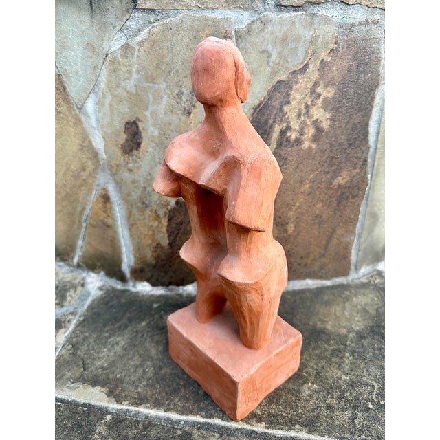 Striking modernist Cubist sculpture depicting an abstracted female figure, hand-modeled in terracotta clay. The form is...