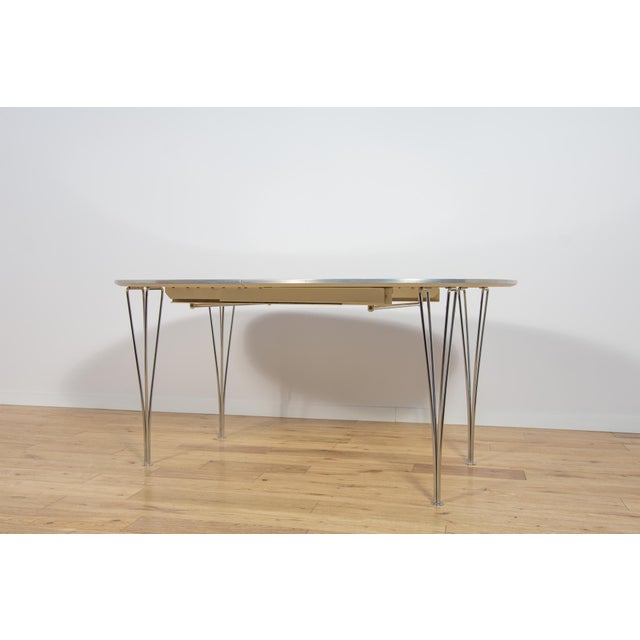 The B612 Superellipse extendable white table was designed by Piet Hein and Bruno Mathsson for the Danish manufacturer...