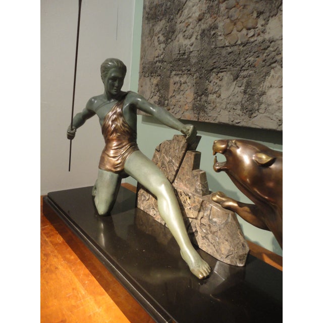 Bronze sculpture of Brault, representing a warrior fighting with a cheetah, both resting on a piece of shaped polychrome...