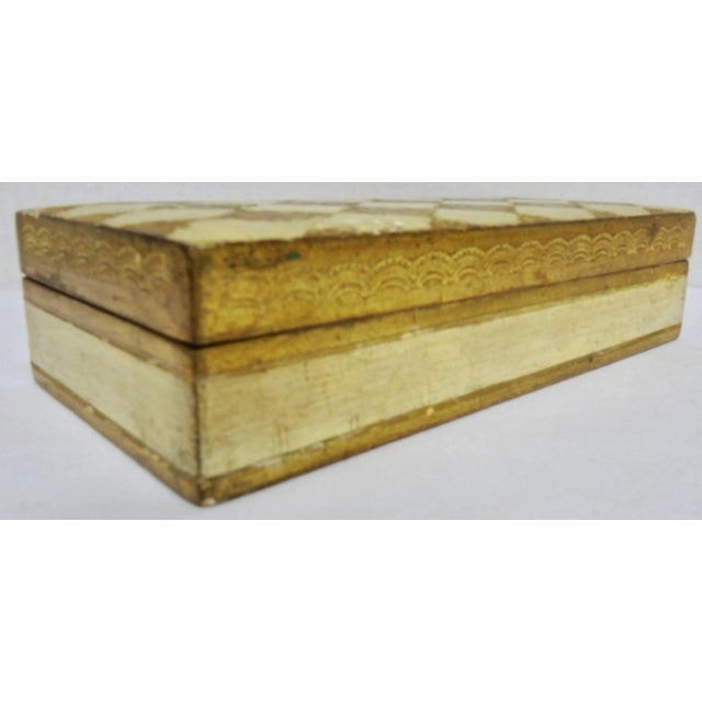 Elegant diamond shapes in gilt decorate the top of this Florentine box with centers of ruby red. The body of the box is...