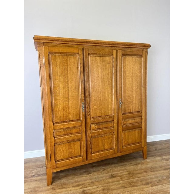 A handsome Vintage French wardrobe in oak, featuring a warm finish, traditional panelled doors and a balanced three-door...