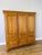 A handsome Vintage French wardrobe in oak, featuring a warm finish, traditional panelled doors and a balanced three-door...