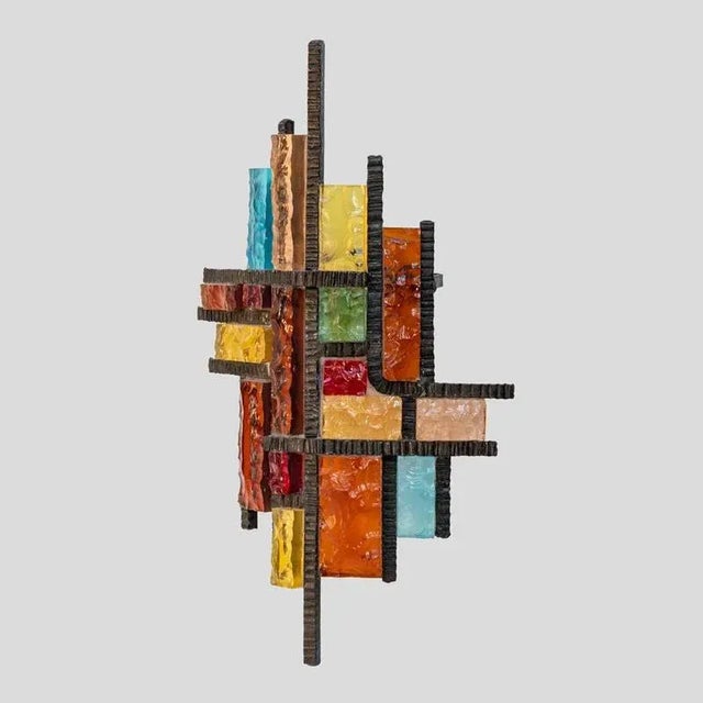 A Brutalist single wall Light wrought iron structure with multicoloured glass components. Italian design by Longobard....