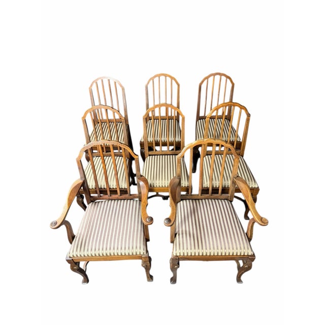 An elegant Stickley dining chair set crafted from solid walnut, featuring two captain’s chairs and six side chairs.