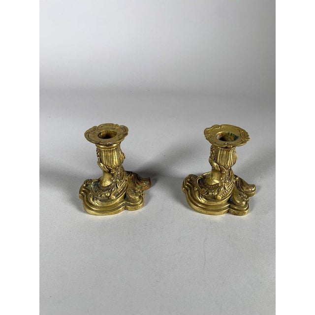 Pair of Rocaille-style gilt bronze candlesticks, 19th century. These Rocaille-style candlesticks, crafted from chased and...