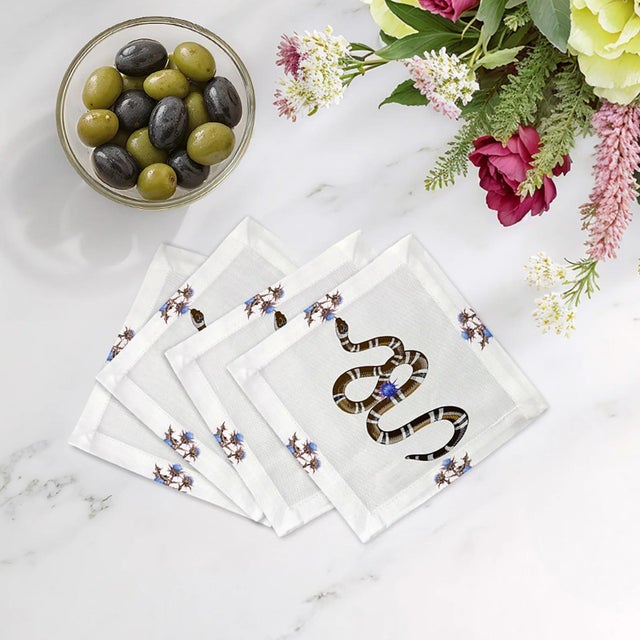 Thistle And Snake Cocktail Napkins intertwine thistle floral patterns with bold serpent motifs, creating a striking mix of...