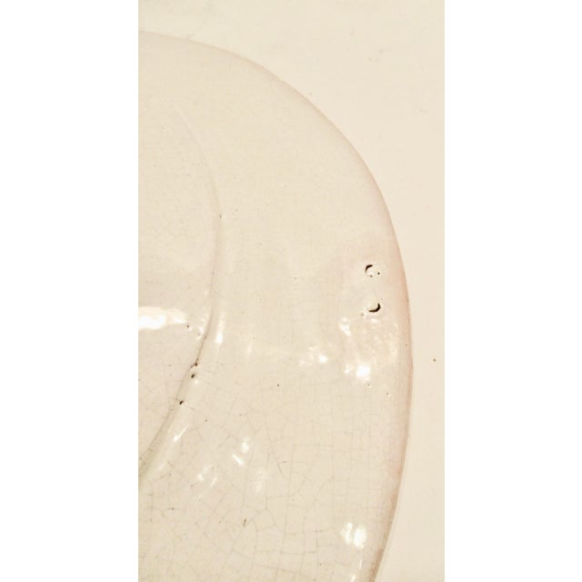 Wide and deep French faience wall decoration. Provincial cream glaze over a red clay body. Face of the Sun as central...