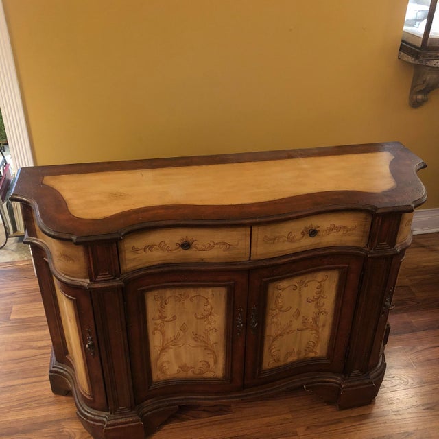 Serpentine Demi painted cabinet with two drawers and two front doors and two side doors. Distressed Brown finish with...