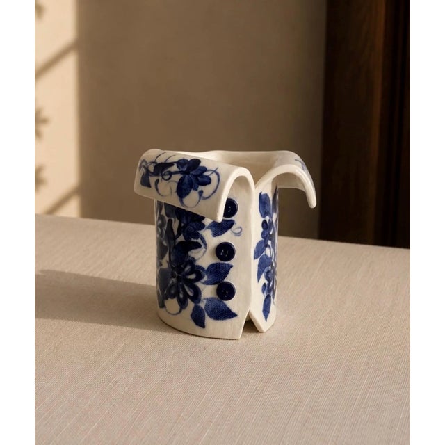 A whimsical and beautifully crafted signed studio pottery vase in the form of a tailored jacket, hand-decorated with bold...