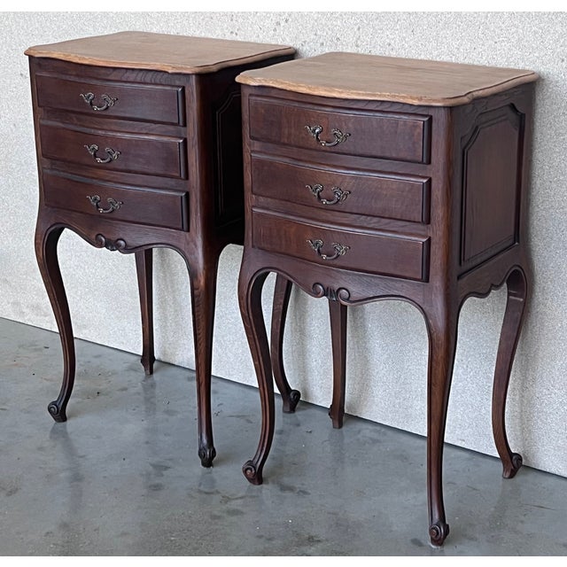A pair of Antique French Louis XV Marquetry light oak top nightstands. Subtle contours and scroll shapes are evident in...
