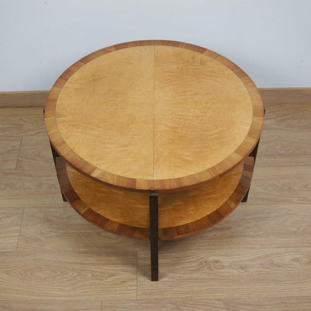 An Art Deco two tiered circular coffee table. Satin birch veneered with figured walnut banding. Dimensions: H 49cm D 68cm...