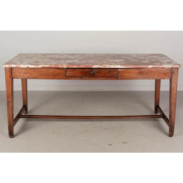 A 19th century French table made of solid cherry wood with beautiful Rouge Royale marble top. Sturdy pegged construction...