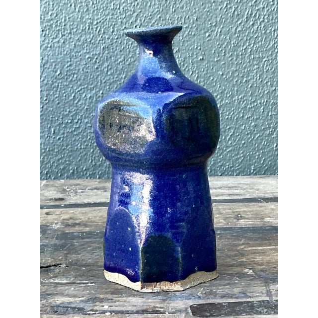 This striking vintage studio pottery vase features a captivating, faceted silhouette finished in a deep, lustrous cobalt...