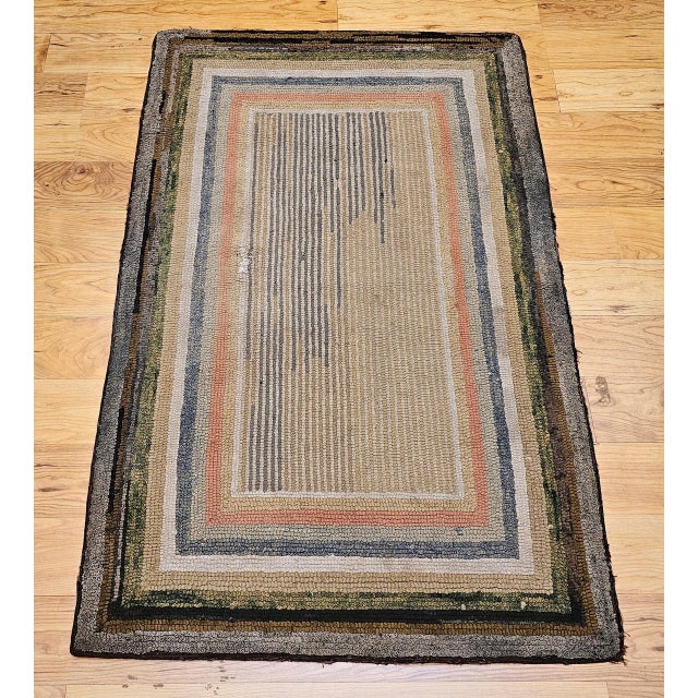 A charming early 20th century American rag area rug handwoven in a concentric stripe field pattern � a composition of...