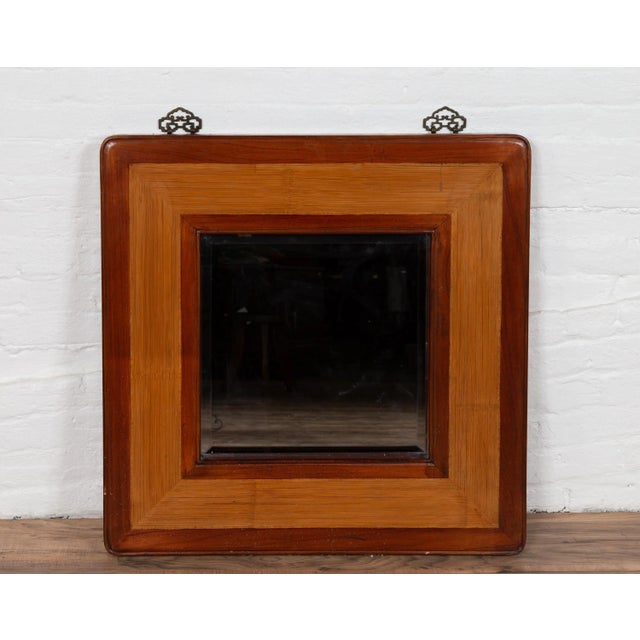 A vintage Chinese square mirror from the mid-20th century, with beveled glass, elm frame and rattan accents. Born in China...