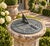 A classic vintage iron garden sundial inspired by traditional English estate landscapes, reading "Grow old along with me....