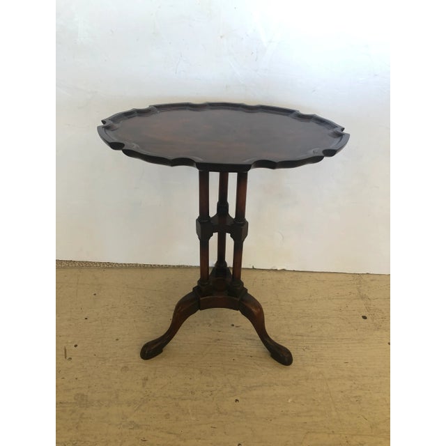 A particularly lovely oval small crotch mahogany side or drinks table having cut out periphery and tripod slipper paw feet.