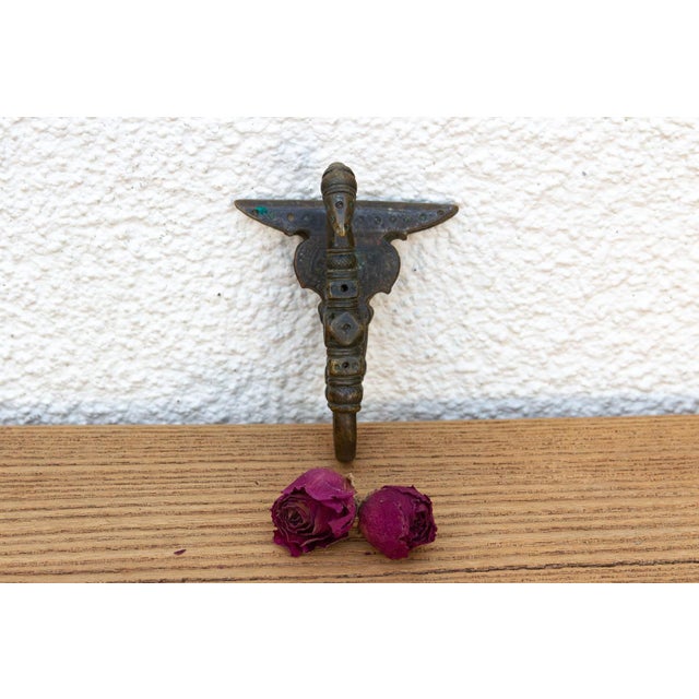 A robust utilitarian antiquity featuring a detailed geometric stem and a stylized architectural bud finial, carrying a...