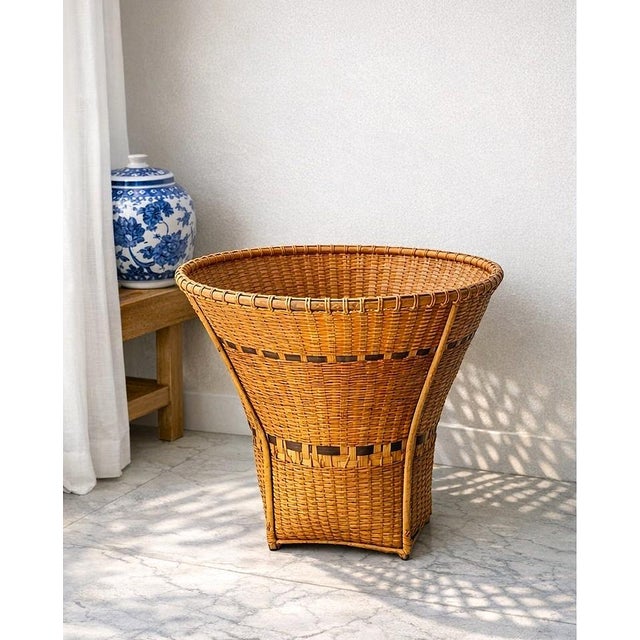 A striking handwoven Southeast Asian market basket distinguished by its sculptural flared silhouette and beautifully...
