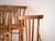 A set of four antique chairs in bentwood, with a curved crest rail over vertical splats and a moulded board seat....