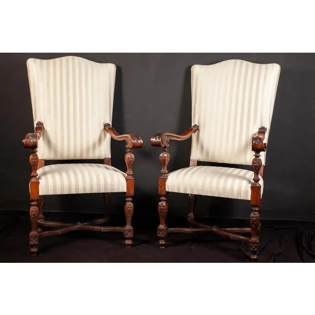 Pair of elegant Italian 19th century walnut finely carved armchairs with a white striped upholstery. Measures: 130 x 60 x 50.