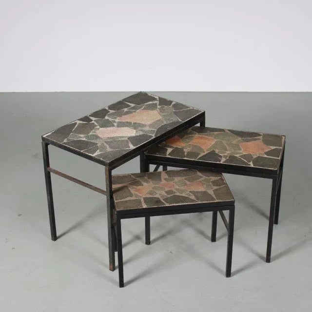 A lovely set of 3 nesting tables, manufactured in the netherlands around 1960. each table has a straight, black lacquered...
