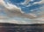 In "Mid-Afternoon," the artist captures a serene landscape where expansive skies filled with billowing clouds reflect a...