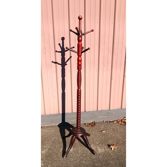 An antique Victorian Hunzinger style mahogany wooden hat and coat rack hall tree dating back to the 1900s. The turned...