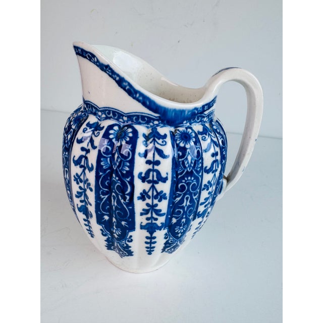 This antique English piece has a blue and white pattern with alternating blue and off white ground stylized floral...