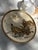 This finely detailed Japanese plate features a narrative scene of four robed figures gathered beneath a flying immortal,...