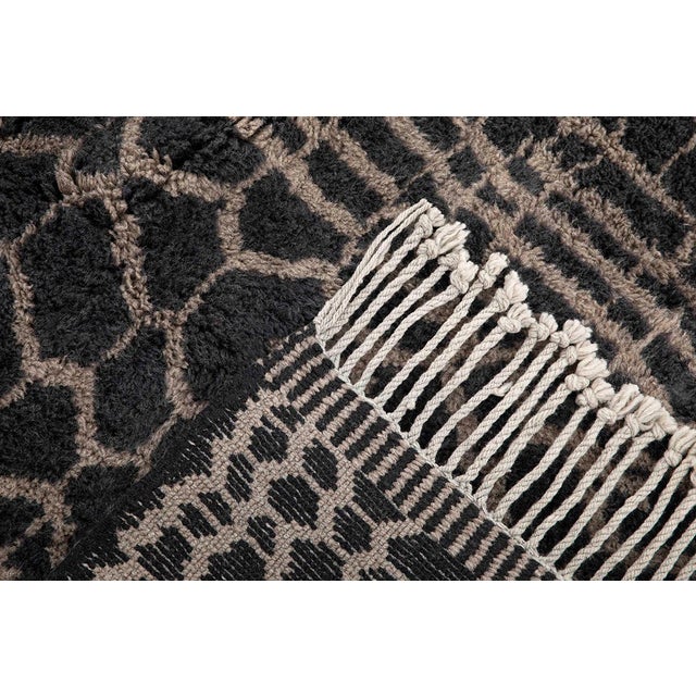 A striking lattice of honeycomb and grid lines emerges in taupe against deep charcoal, giving this rug the graphic energy...