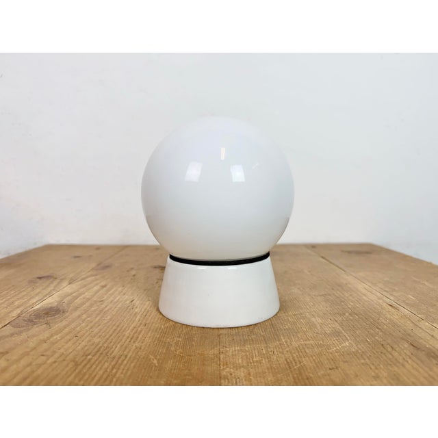 Vintage industrial ceiling or wall light made in former Czechoslivakia during the 1970s. It features a white porcelain...