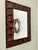 Description: Sculptural wall mirror featuring a striking hammered metal frame with a rich copper and bronze patina. The...