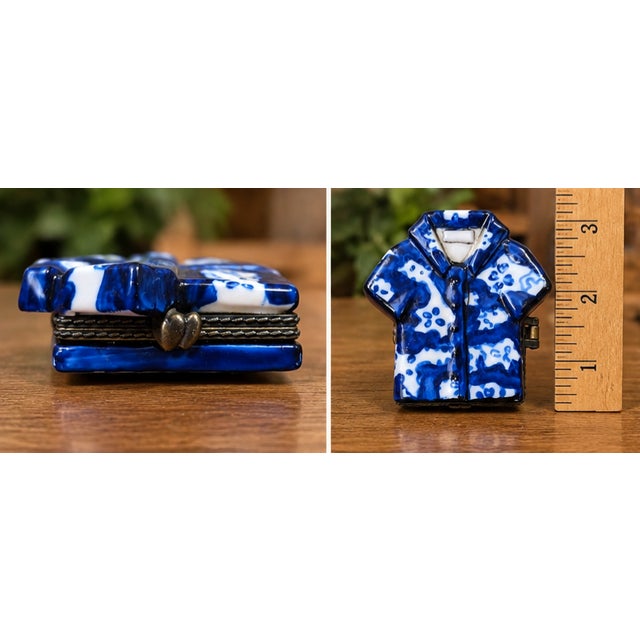 Charming miniature porcelain hinged trinket box designed in the whimsical form of a blue-and-white patterned shirt. The...