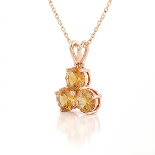 A radiant three-stone design featuring round-cut natural citrines arranged in a graceful trefoil formation, secured in a...