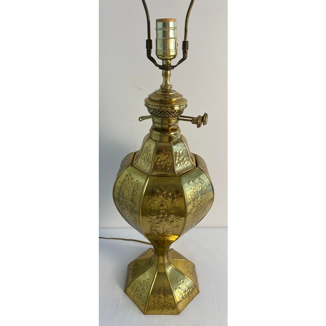 Distinctive vintage brass table lamp featuring an unusual faceted, bulbous body richly decorated with engraved and chased-...