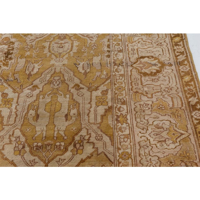 A hand-knotted wool antique Indian Amritsar size adjusted rug dating back to circa 1920. The main field features geometric...