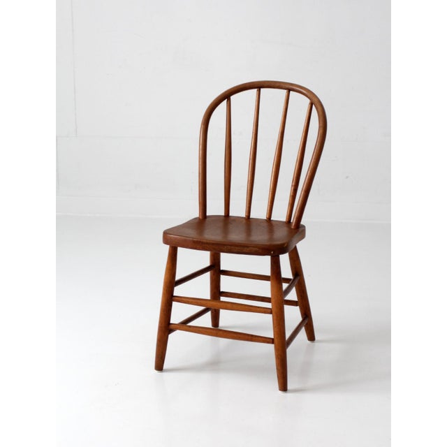 Classic Windsor chair with a warm, inviting presence. The curved hoop back and slender spindles create an open, airy...