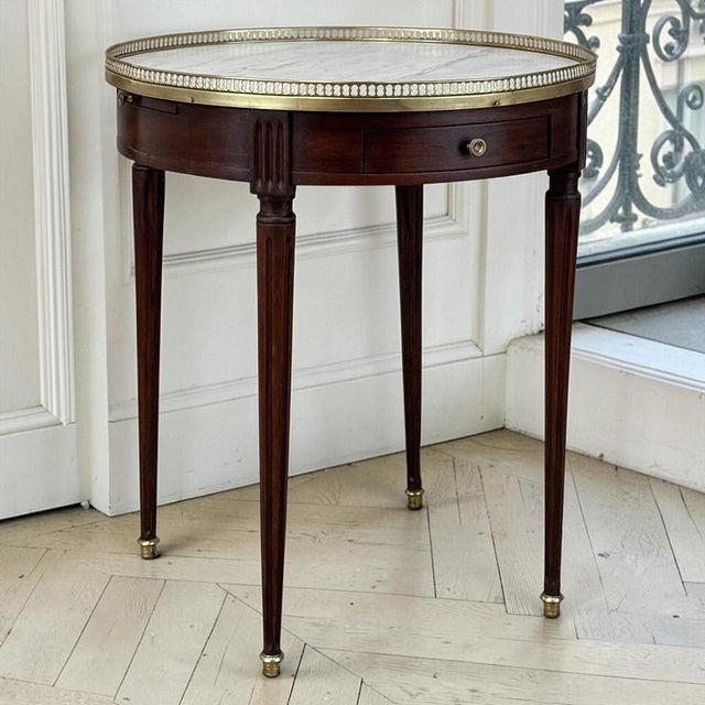 Created in the tradition of the celebrated French bouillotte table, this Louis XVI style example combines fine mahogany,...