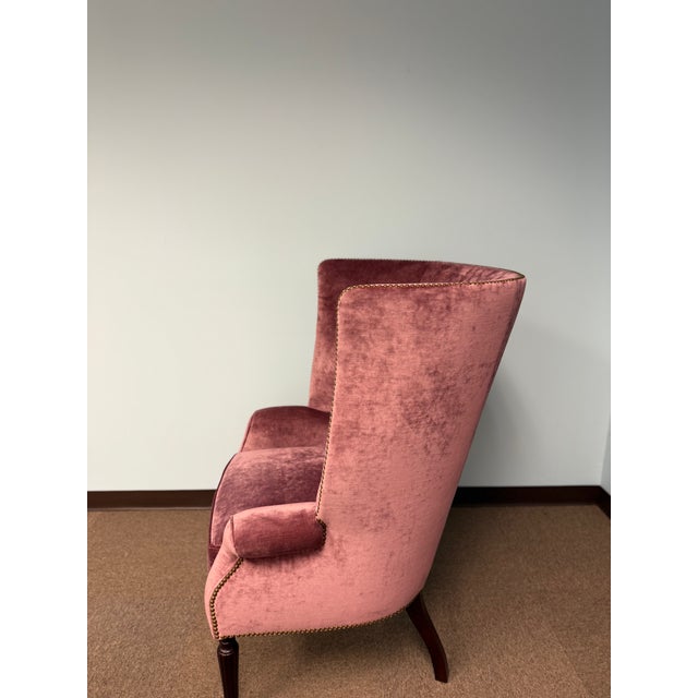 Elegant velvet upholstered accent chair featuring a sculptural scalloped back, rolled arms, and decorative nailhead trim....