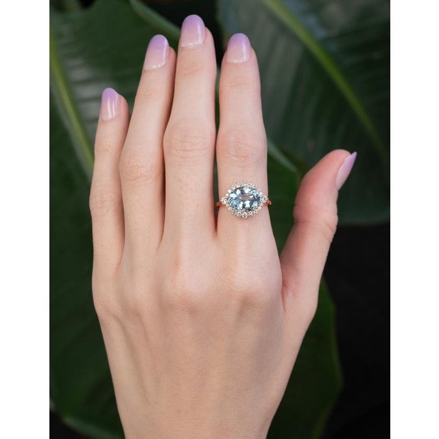 A luminous 3.1ct aquamarine in an elegant 11x9mm oval cut glows with serene ocean-blue brilliance. Accented with natural...