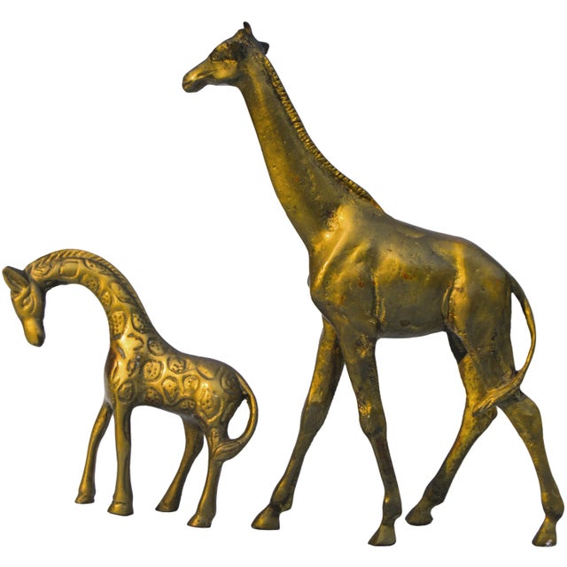 Set of two vintage solid giraffes. Featuring ornate details and natural patina. No maker's mark. Baby giraffe measures:...