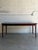 This large dining table features a sleek rectangular top bordered by refined solid edges. The versatile frame incorporates...