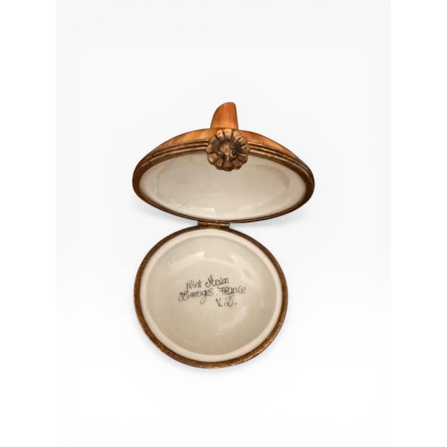 A beautifully rendered hand-painted Limoges porcelain trinket box, crafted in France and modeled in the form of a...