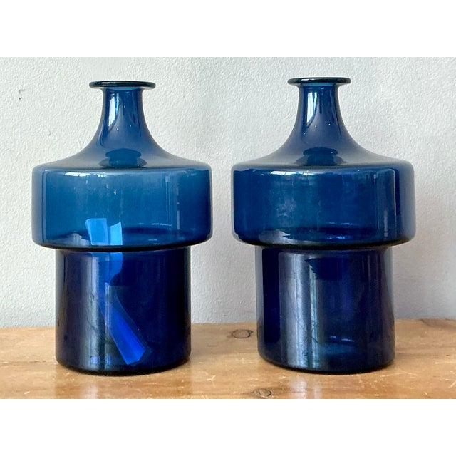Elevate your barware collection with this exquisite pair of vintage glass decanters, designed by the legendary Timo...
