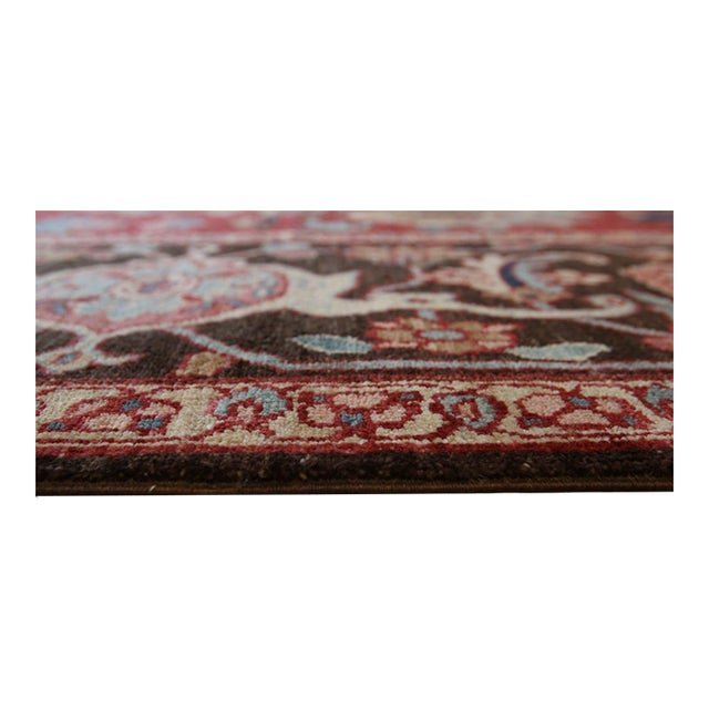 A hand-knotted wool rug, made in India and measuring 8' x 10'. Floral drawing carried across the field inside a...