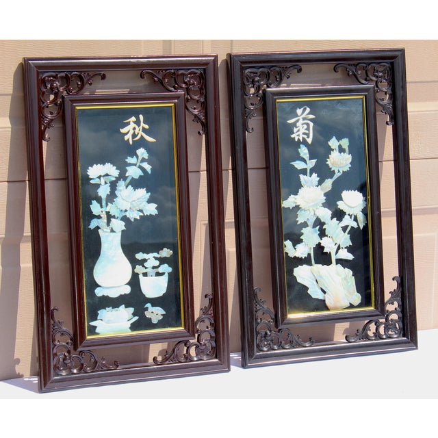 Elegant vintage Chinese wall panels featuring intricate mother-of-pearl inlay depicting floral arrangements, beautifully...