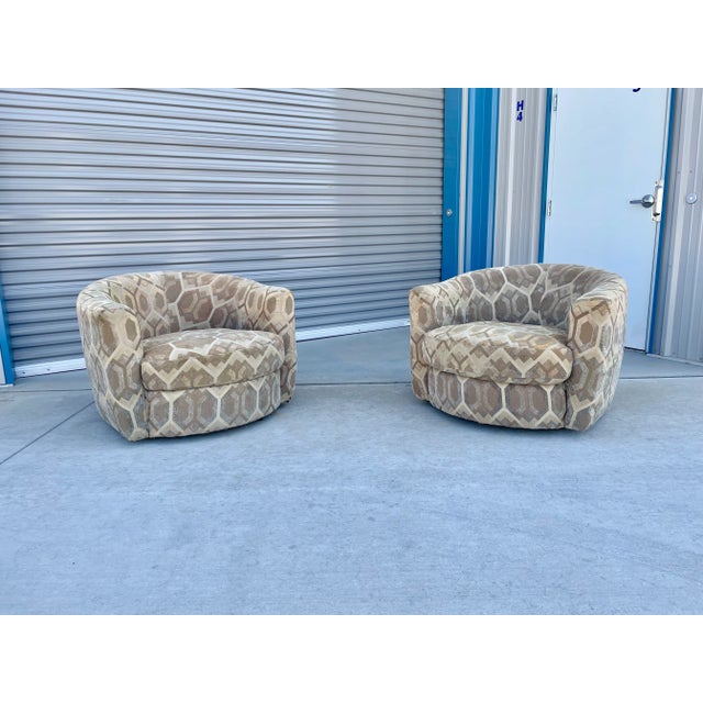 This striking pair of mid-century modern style swivel lounge chairs combines dynamic geometric patterning with a cozy,...